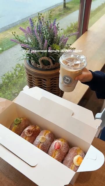 A box of Truffle Donut flavours with an iced drink by the window